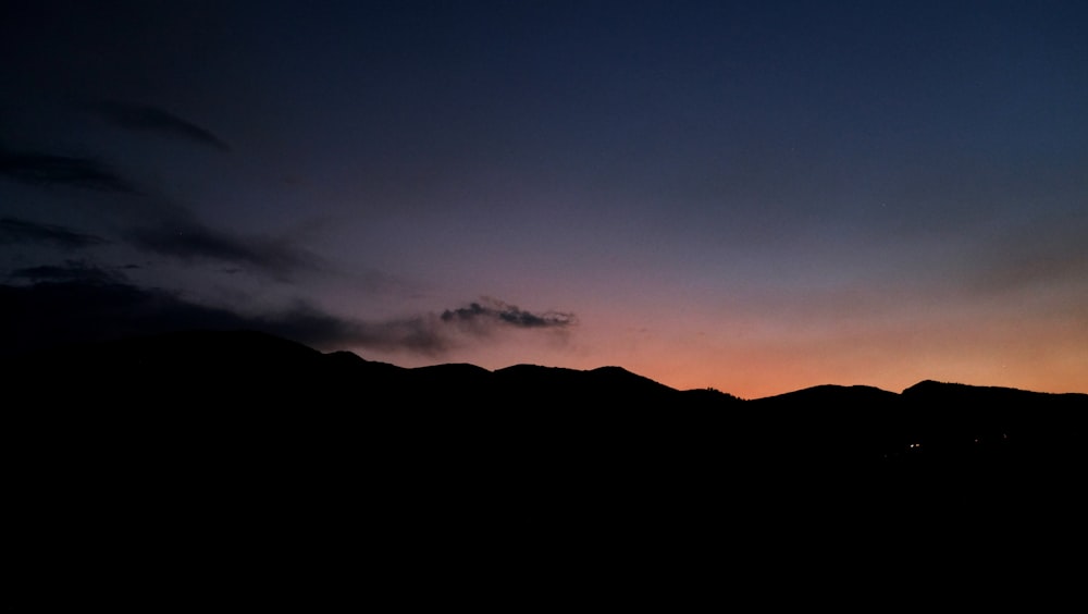 silhouette de montagne pendant le coucher de soleil orange