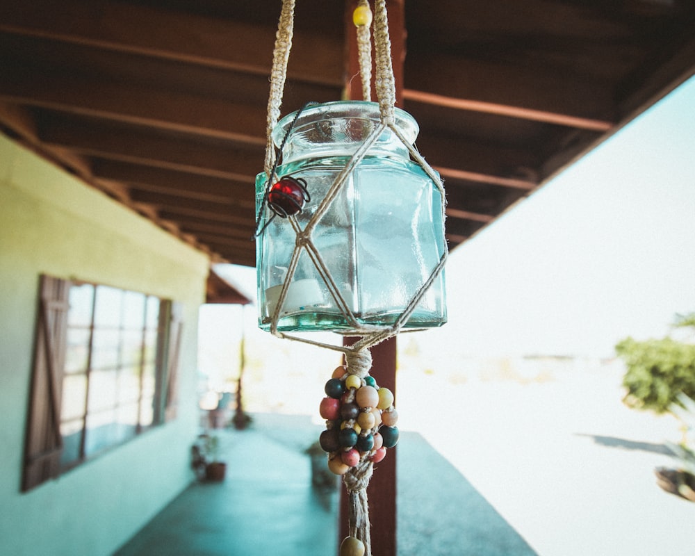 a glass jar hanging from a wooden pole