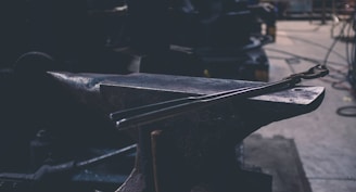 gray metal hand tool on gray bench