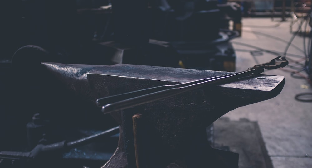 gray metal hand tool on gray bench