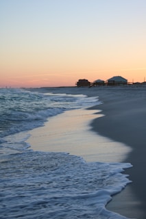 Sunset view over Longboat Key beach with gentle waves and soft sand.