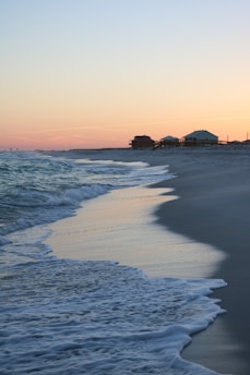 Sunset view over Longboat Key beach with gentle waves and soft sand.