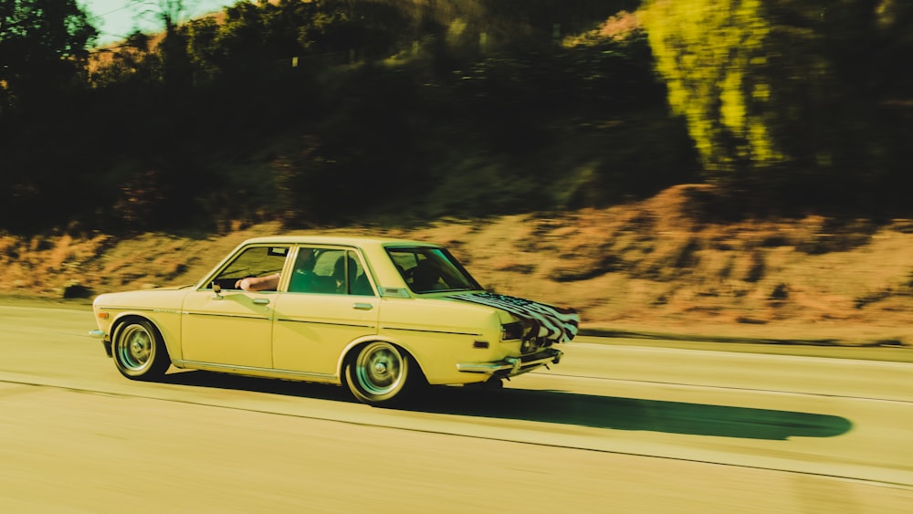 beige sedan traveling near road during daytime