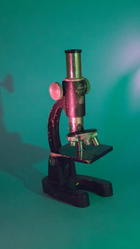 An antique ophthalmic microscope displayed on a wooden table with soft natural light.