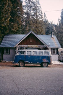 A delivery van parked in front of a rustic cabin.