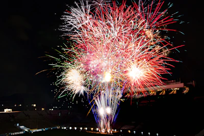 A panoramic view of the stadium with fireworks lighting up the night sky.