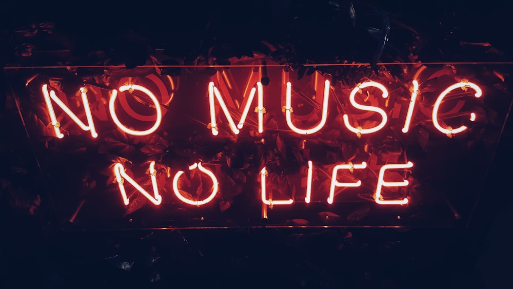 A red neon reads âNo music, no lifeâ against a dark background