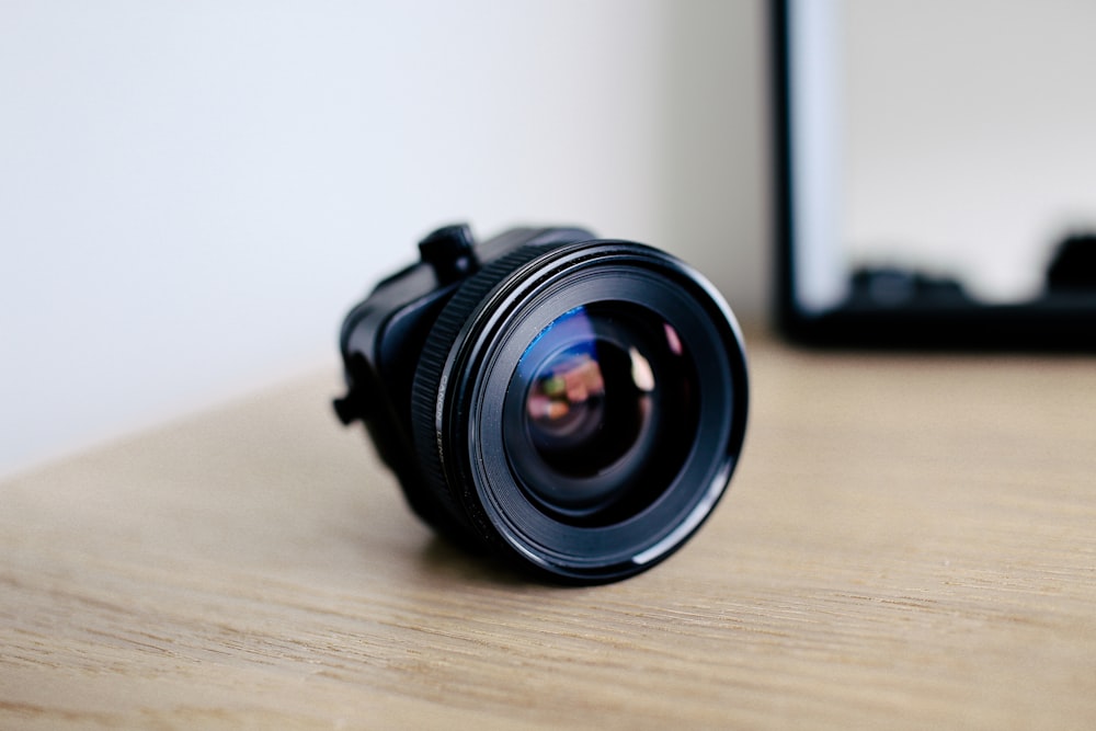 round black zoom lens on brown wooden surface