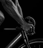 grayscale photography of man riding bicycle