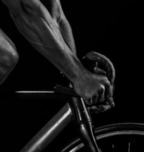 grayscale photography of man riding bicycle