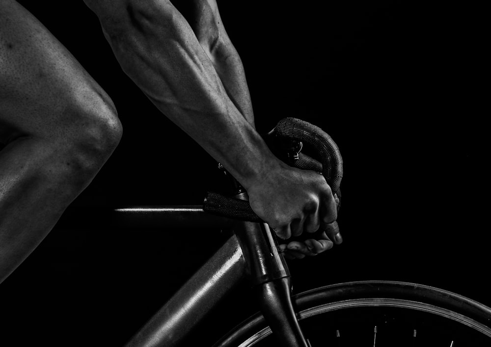 grayscale photography of man riding bicycle