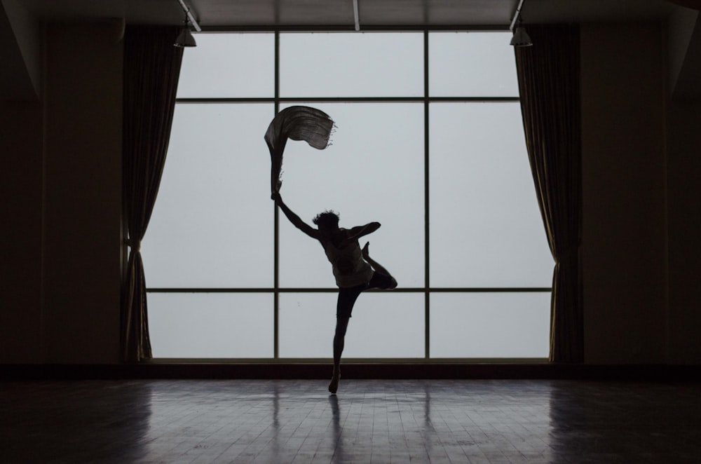 silhouette of man standing beside window