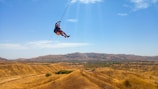 An exhilarating zipline ride soaring over the dramatic mountain terrain.