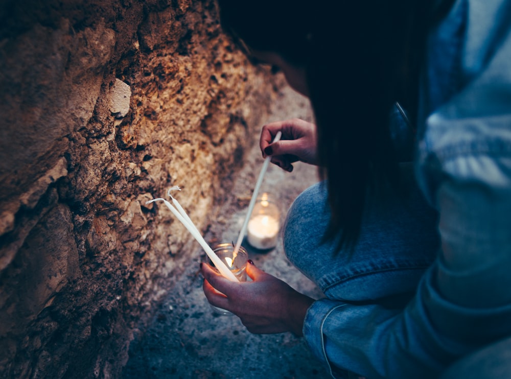 woman holding white pillar candles