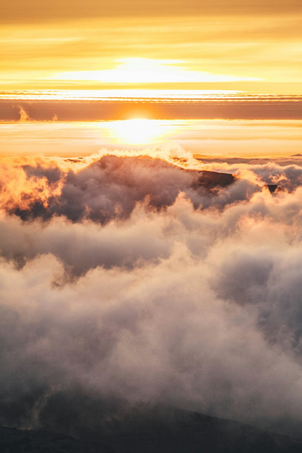 montagne couverte de nuages pendant l’heure dorée