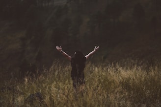 man raising arms between greenfield