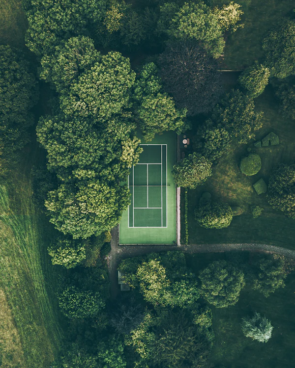 Aerial view of a tennis court surrounded by trees, representative photo — not the actual Independence Park