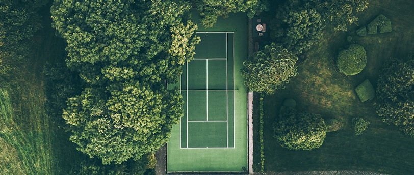 aerial photo of tennis court surrounded with trees