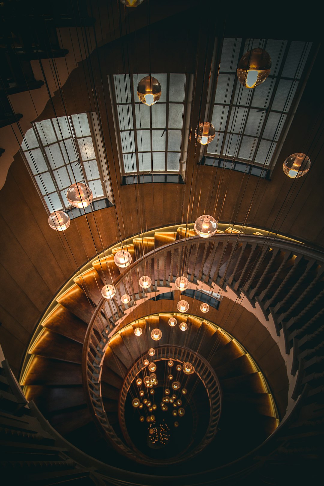 Looking down on a spiral staircase with hanging lightbulbs at Heal's
