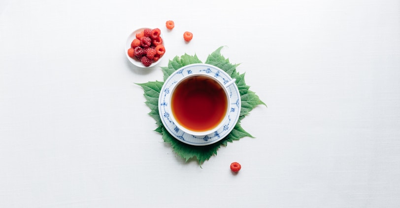 round white cup with saucer filled with red liquid