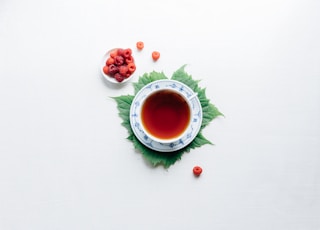 round white cup with saucer filled with red liquid