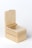 A wooden box with smooth edges and a latch on top. The box is open, revealing a round compartment inside. The wood has a light, natural finish with visible grain patterns.