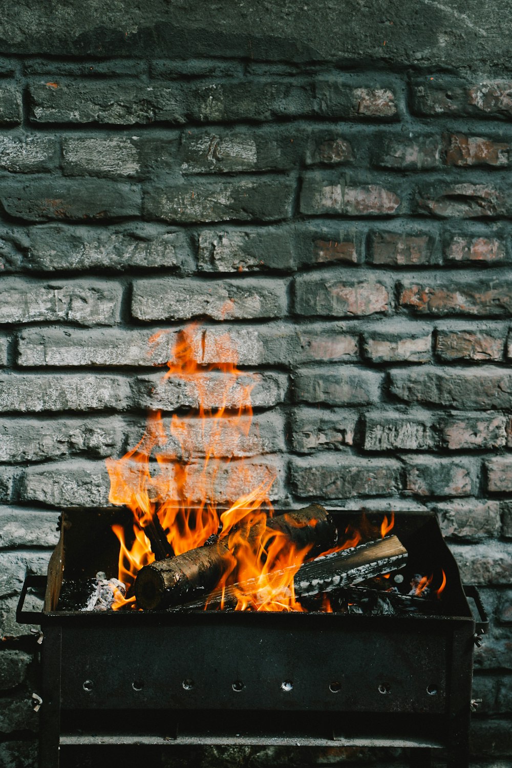 Holzscheite auf Holzkohlegrill verbrennen