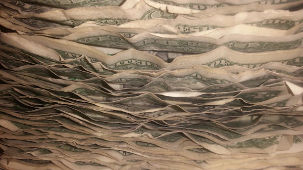 A stack of crisp replica dollar bills fanned out with a soft studio light highlighting the details.
