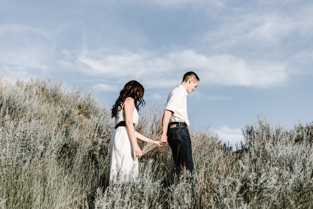 couple walks of grassy field