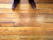 Polished brown leather formal shoes resting on a wooden floor with soft natural light