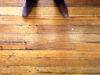Polished brown leather formal shoes resting on a wooden floor with soft natural light
