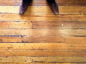 Pair of classic brown leather shoes placed on a rustic floor