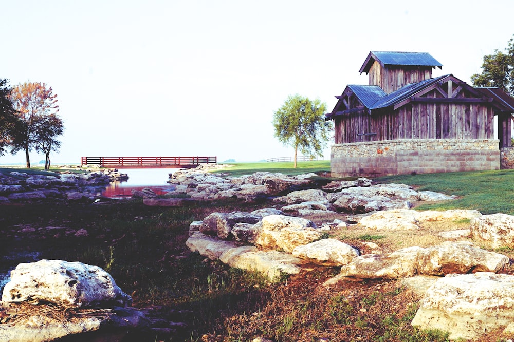 brown wooden house near green grass field during daytime