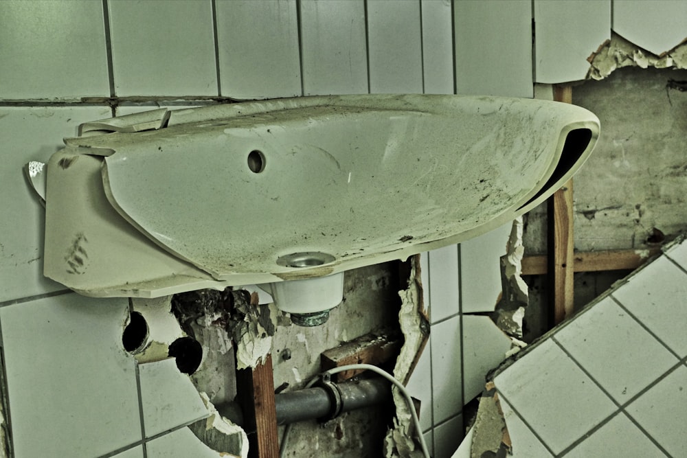 A broken apart bathroom sink vanity and wall.