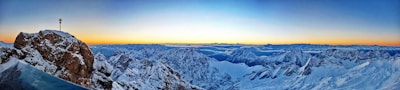 A panoramic view of snow-capped peaks at sunrise, capturing the spirit of adventure