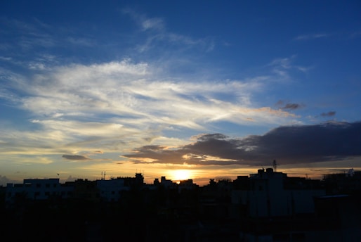 A digital rendering of a cloudy sky over a cityscape at sunset