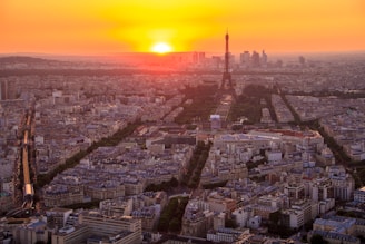 Aerial view from the top of a tall tower overlooking a cityscape at sunset.