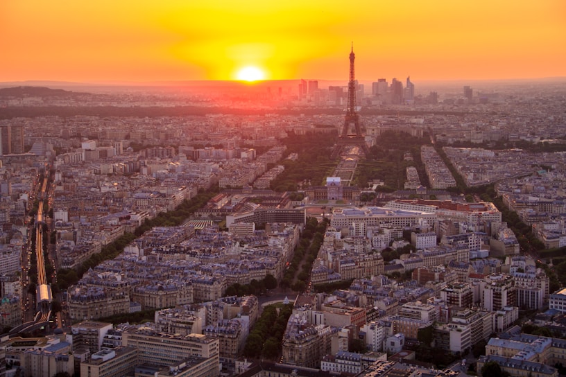 Aerial view from the top of a tall tower overlooking a cityscape at sunset.