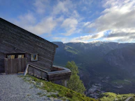 An expert guide sharing stories with senior travelers beside a rustic mountain cabin.