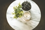 white votive candle near plant pot