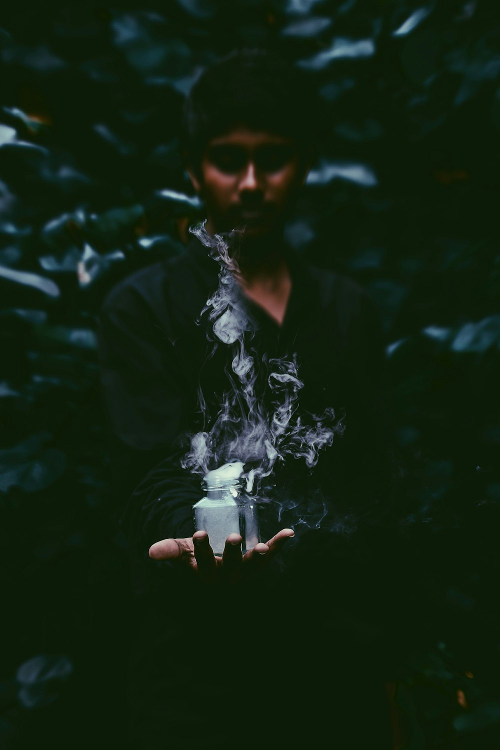 hombre sosteniendo un frasco con humo