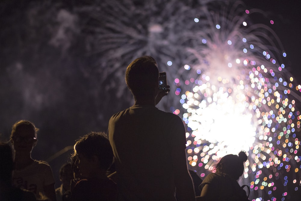 man taking picture of firecracker