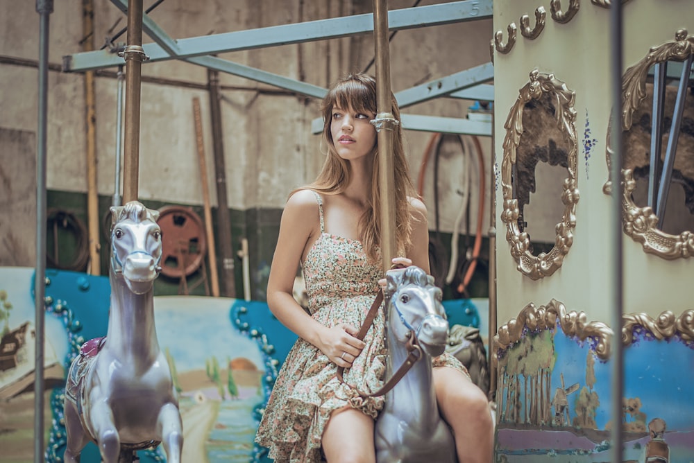 woman in gray floral dress riding carousel