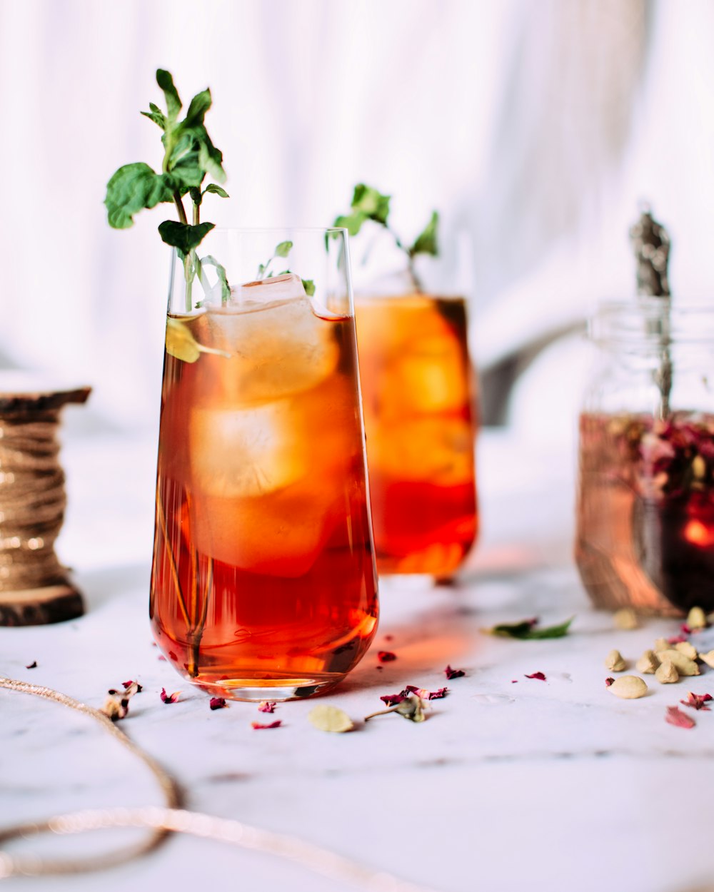 red liquid with ice and plant