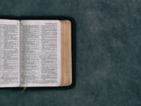open pocket bible on green surface