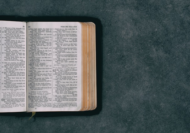 open pocket bible on green surface