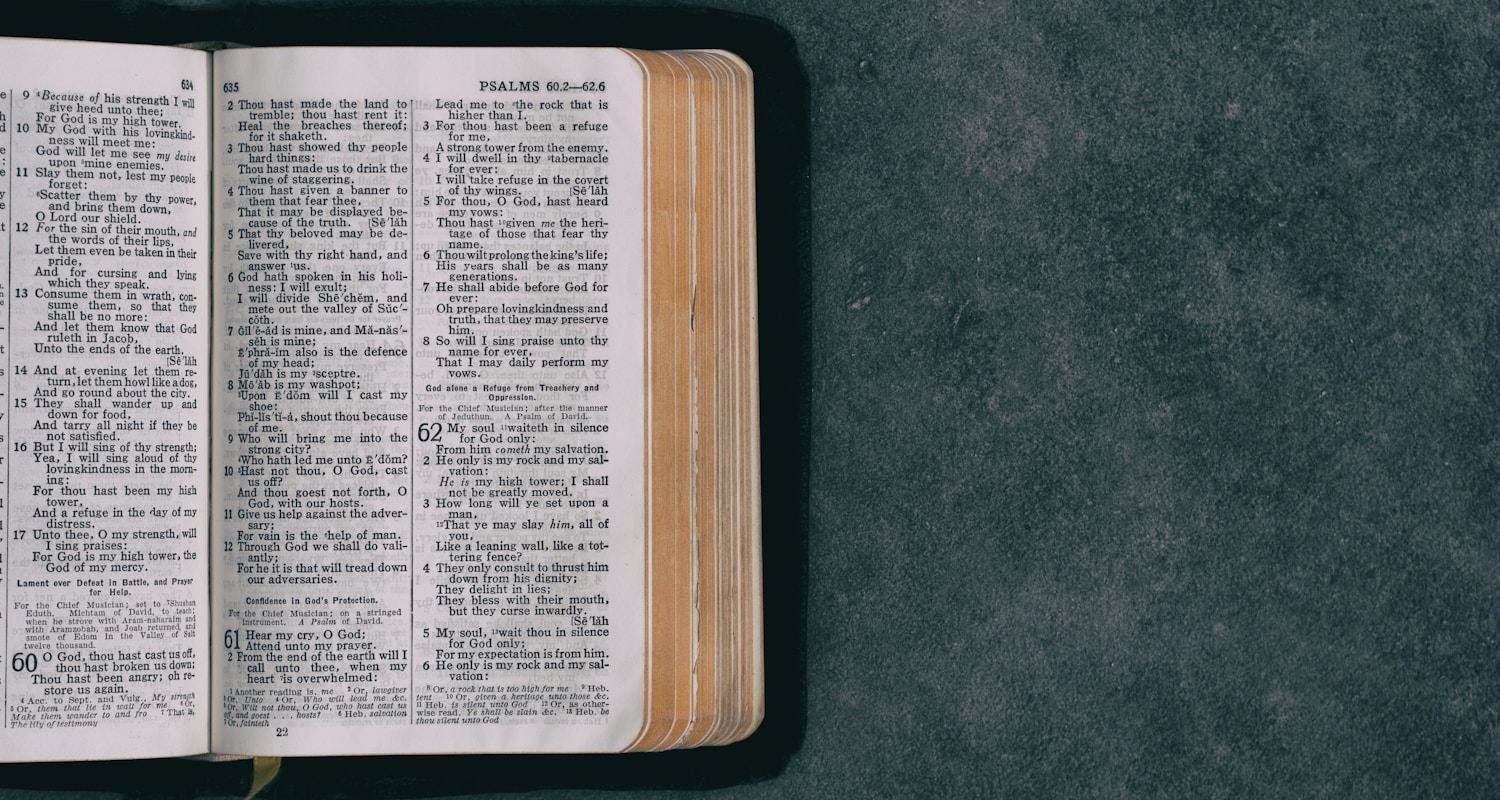 open pocket bible on green surface