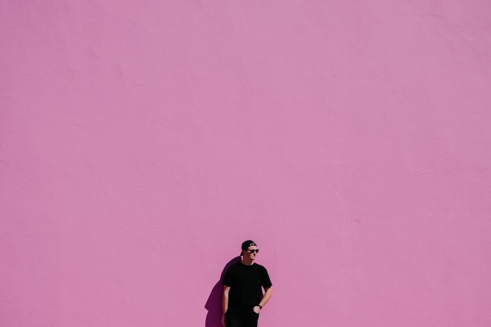 uomo in camicia nera su sfondo rosa