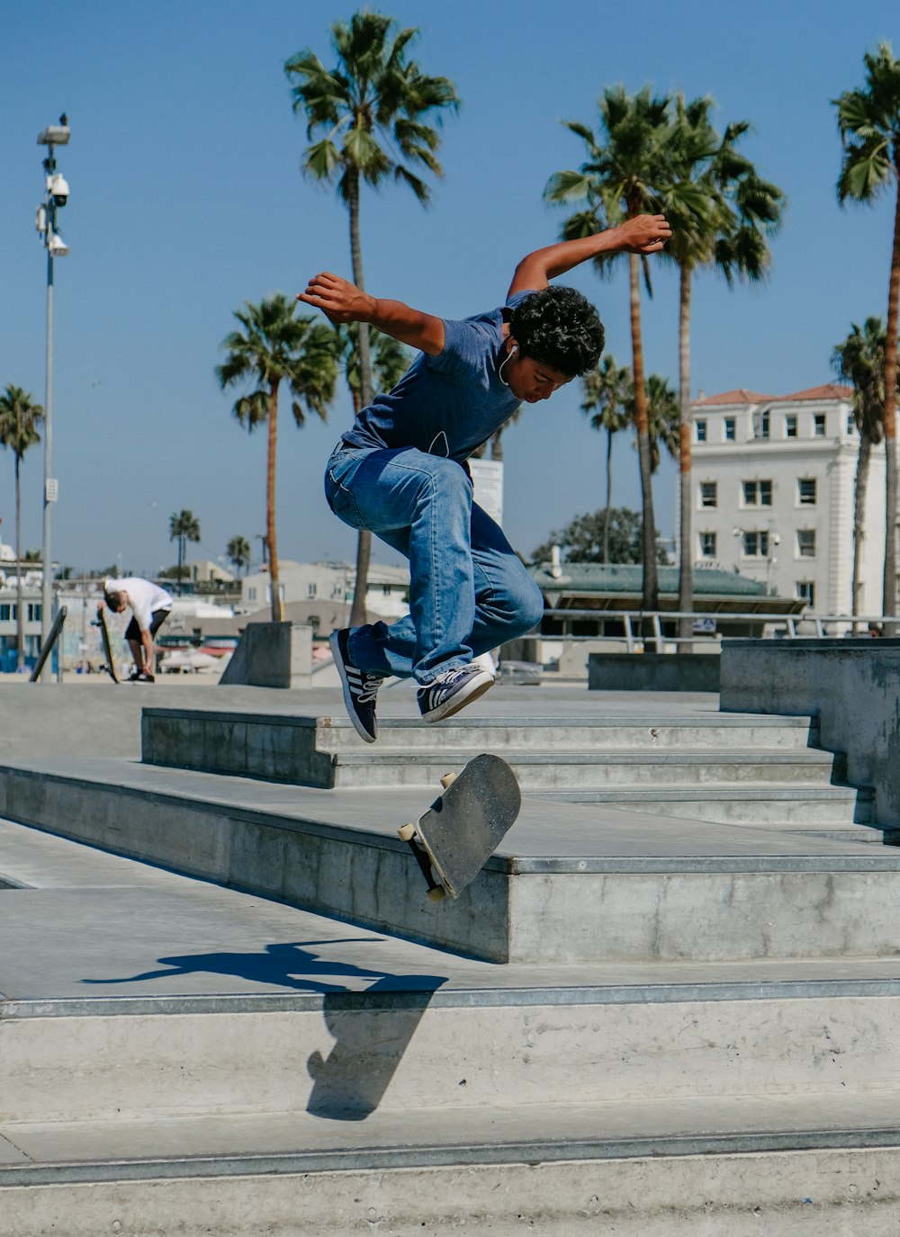Uomo che gioca skateboard su scale di cemento grigio