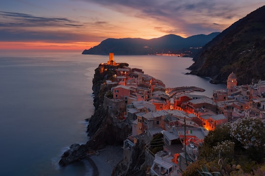 aerial view of village on mountain cliff during orange sunset in Parco Nazionale delle Cinque Terre Italy